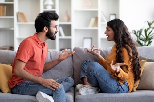 young couple arguing on couch