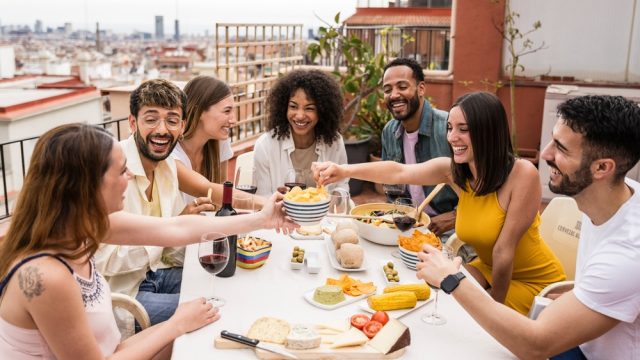 Group of diverse friends laughing at a dinner party