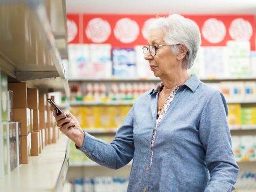 older woman checking food products with food scanner app