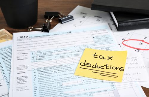 post-it with tax deductions on tax return form