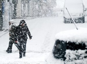 People walking on city streets during a winter snowstorm