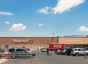 Albuquerque, New Mexico, USA - June 27, 2011: People with shopping carts on the parking lot of the North West Albuquerque Walmart Super-center. Coca-Cola delivery truck parked in front of the store. Picture taken midday.