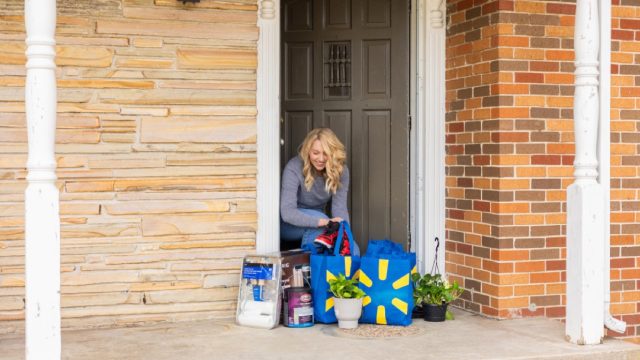 Shopper opening her front door to pick up delivery order off porch
