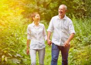 Happy senior couple taking a walk in summer in a forest