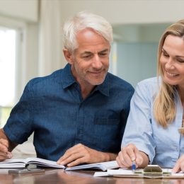 Mature couple reviewing documents at home