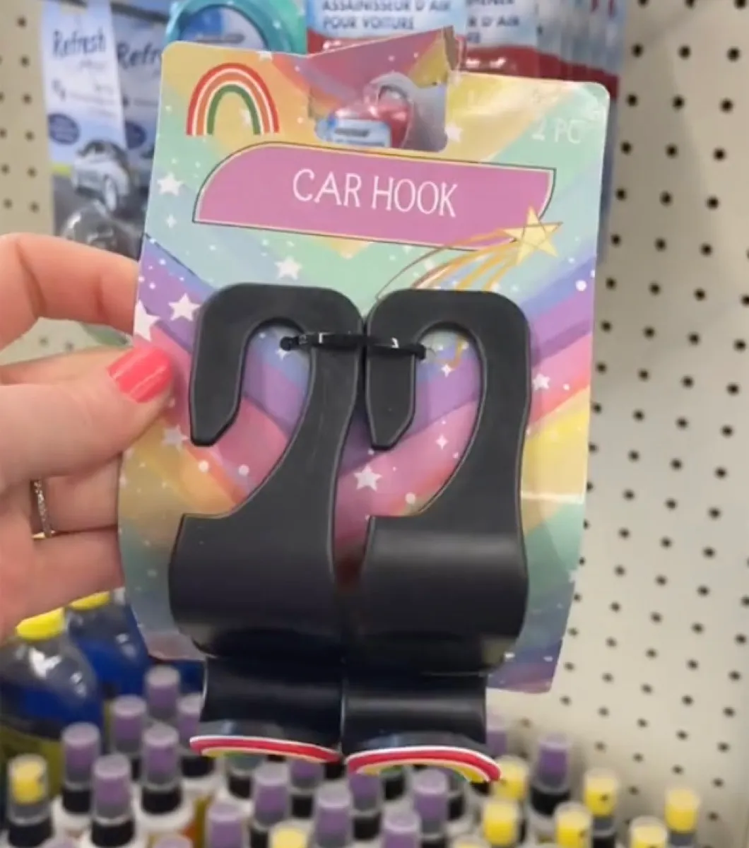 Woman's hand holding car hooks in store
