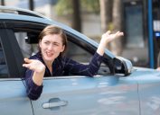 Annoyed woman leaning out of the passenger side of a car