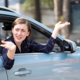 Annoyed woman leaning out of the passenger side of a car