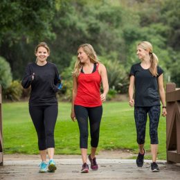 Group of three women in their 30s walking together outdoors