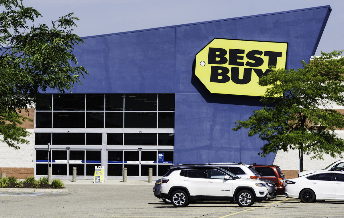 A Best Buy storefront with cars in the parking lot