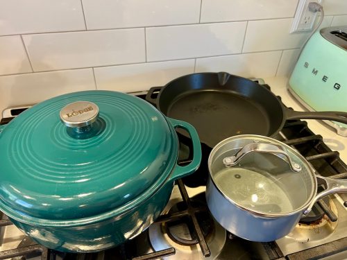 Blue and green pots and pans on a stove
