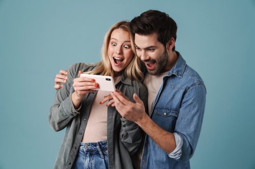 man and woman look shocked while reading jokes on their smartphone