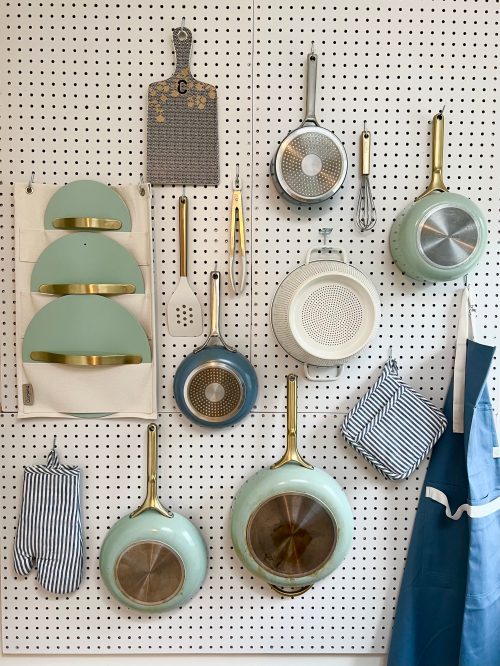 blue and green pots and pans on a peg board