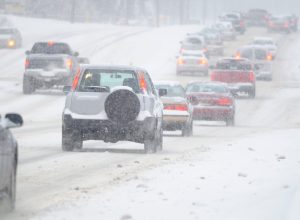 Cars driving on a highway during a snowstorm
