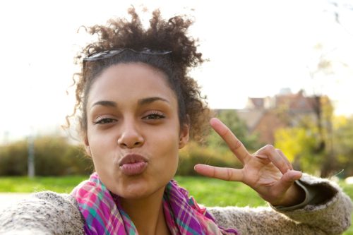 woman taking a selfie while doing a peace sign
