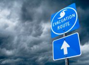 A close up of a hurricane evacuation route road sign with storm clouds in the background