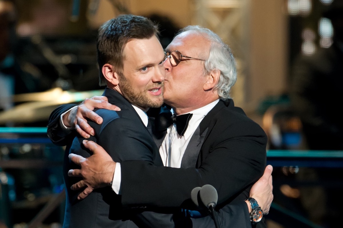 chevy chase kissing joel mchale on the cheek at the comedy awards