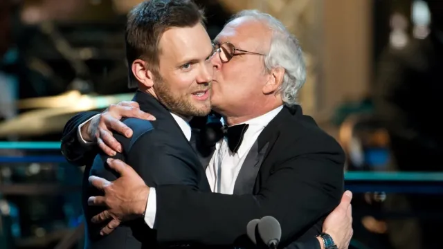 chevy chase kissing joel mchale on the cheek at the comedy awards