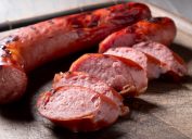A close up of sliced pieces of turkey kielbasa sausage on a cutting board