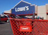 Lowe's shopping cart in parking lot with storefront in the background