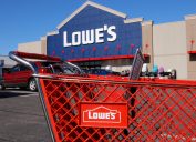 Lowe's shopping cart in parking lot with storefront in the background