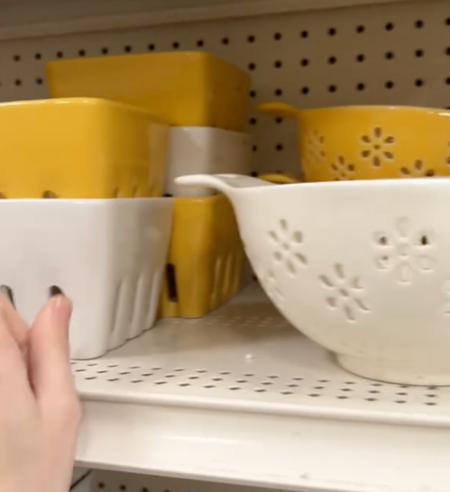 Display of yellow and white ceramic berry bowls and colanders