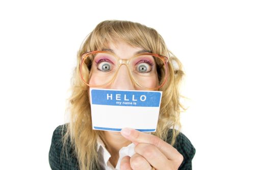 funny woman holding a name tag up to her face