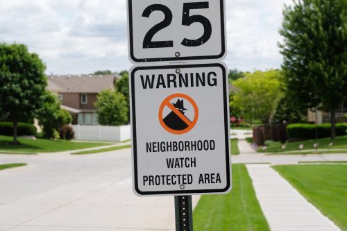 Neighborhood watch sign in a sunny Midwest suburb.