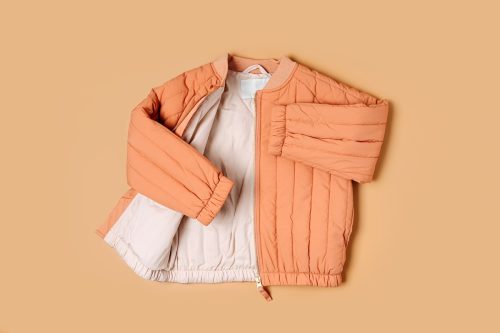 quilted peach bomber jacket on a peach background