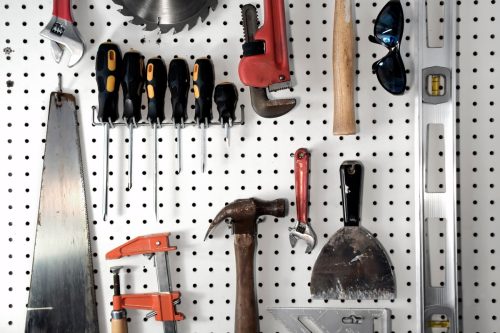 Various carpentry tools in a garage on pegboard