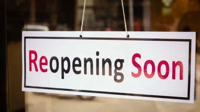 Close up of a sign that reads, "reopening soon"