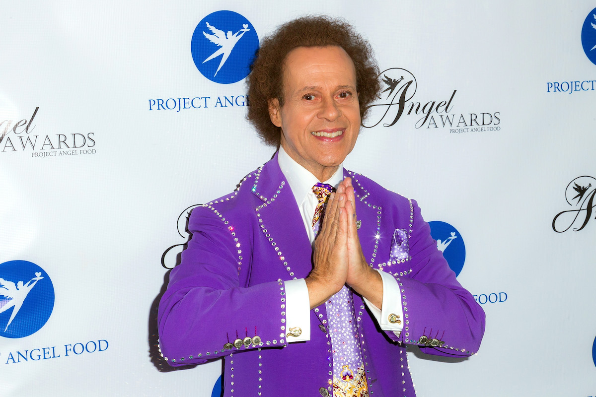 Richard Simmons posing in a purple suit