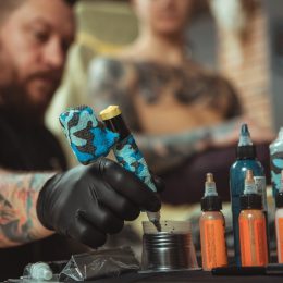 tattoo artist refilling pen with tattoo ink