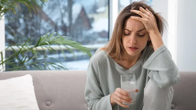 woman with hangover drinking water