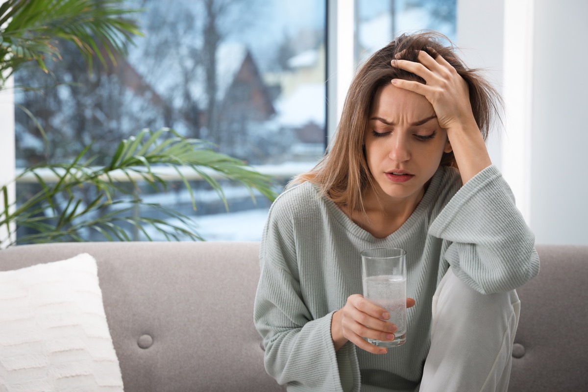 woman with hangover drinking water