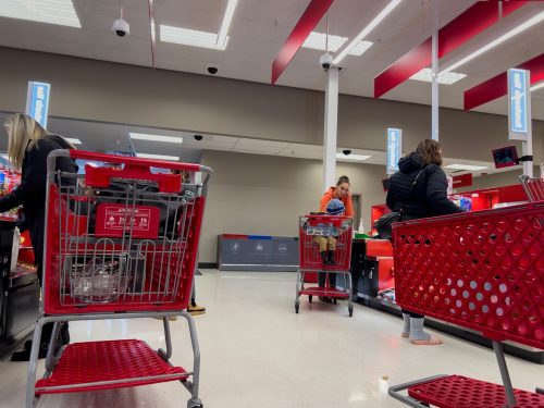 Wide view of people using the self checkout counters inside a Target retail store.