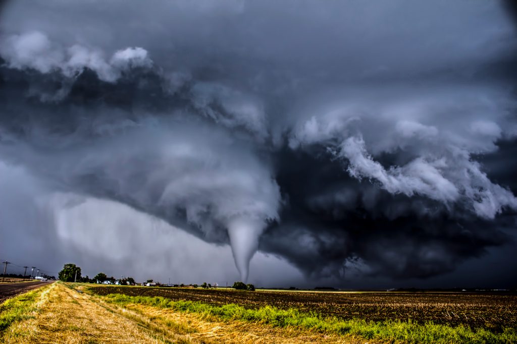 A tornado in a field surrounded by dark clouds