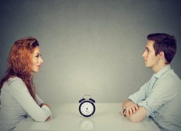 man and woman sitting across from one another asking the 36 questions that lead to love