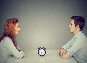 man and woman sitting across from one another asking the 36 questions that lead to love