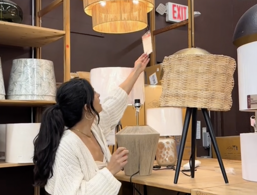 Young woman looking at lamps at a World Market store