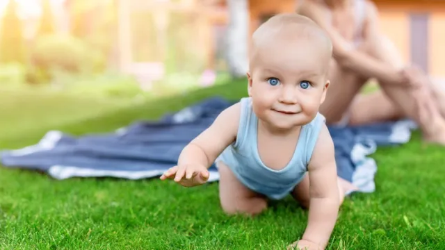 Portrait of baby having fun on green lawn