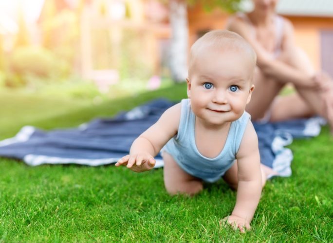 Portrait of baby having fun on green lawn