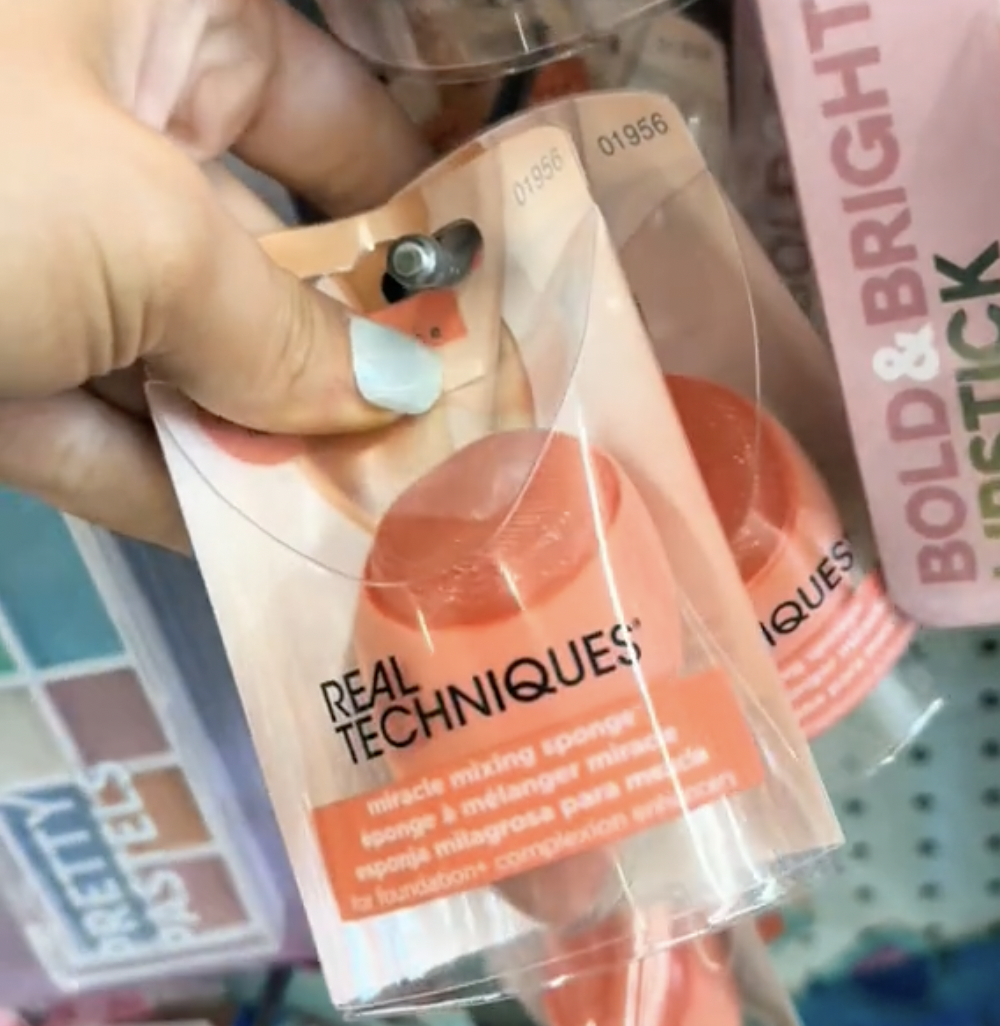 Woman's hand holding a makeup sponge in Dollar Tree
