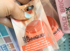 Woman's hand holding a makeup sponge in Dollar Tree