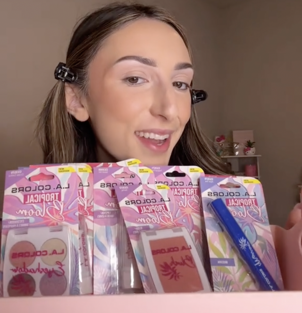 Young woman holding up makeup products from Dollar Tree