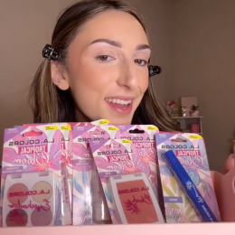 Young woman holding up makeup products from Dollar Tree