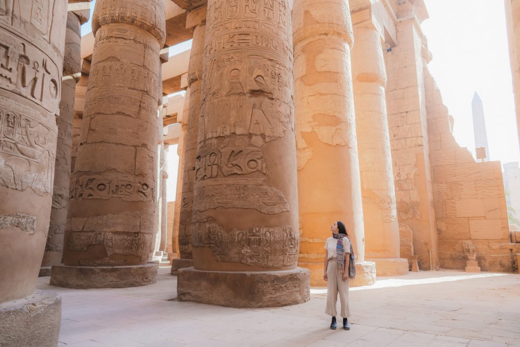 A woman walking among the ruins in the temple in Luxor, Egypt