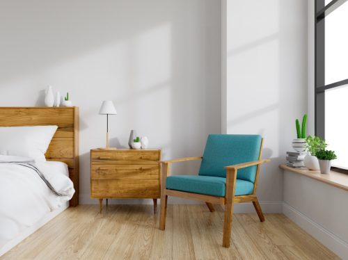 Modern mid Century and vintage interior of bedroom ,blue lounge chair with wood bedside table and white bed on white wall and wood floor in front of a window ,empty room ,3d rendering