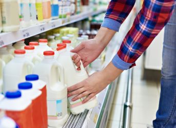 Woman shopping milk in grocery store