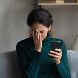 woman stressed out holding her phone